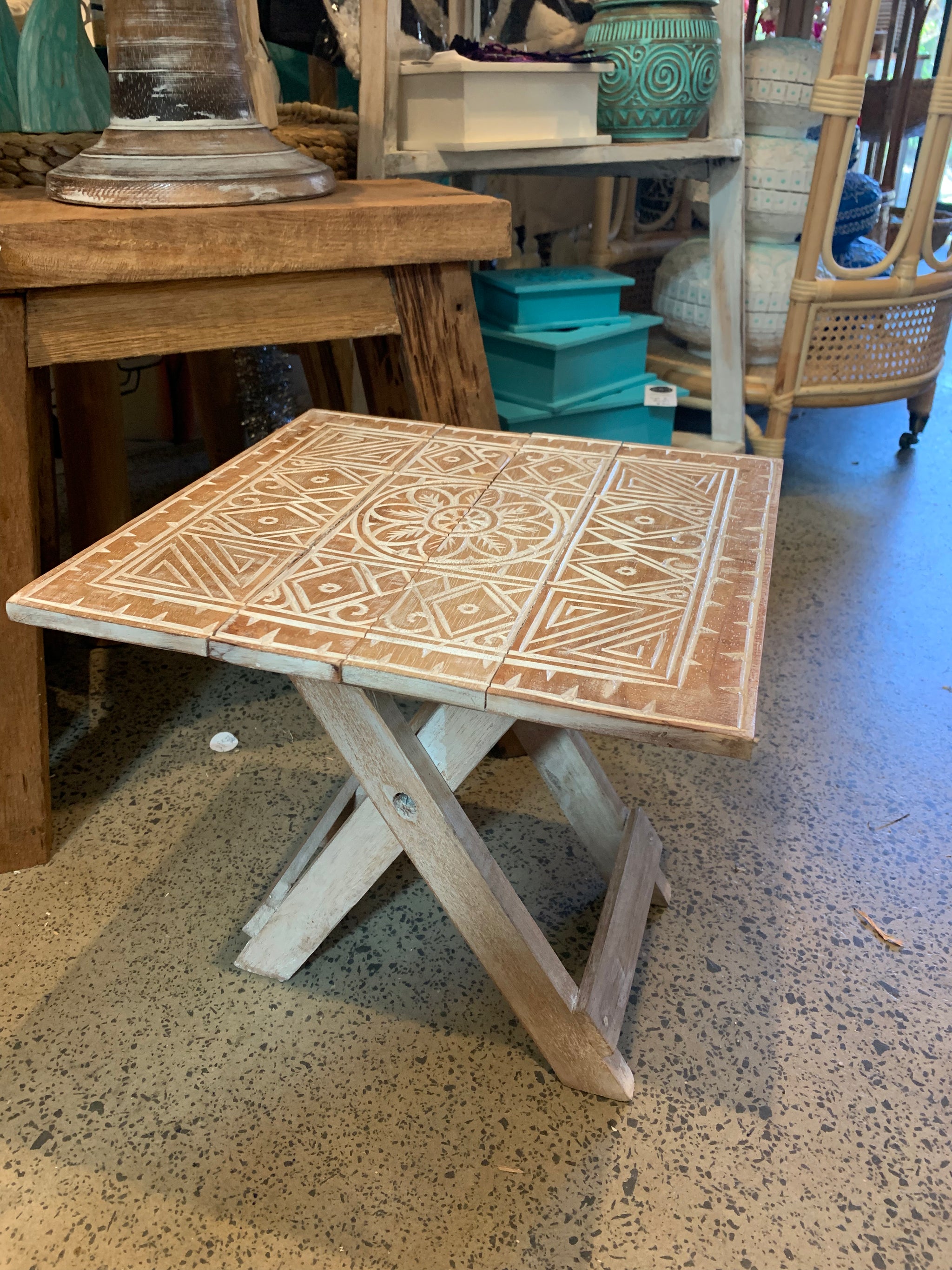 Folding timber carved design table. Natural finish.