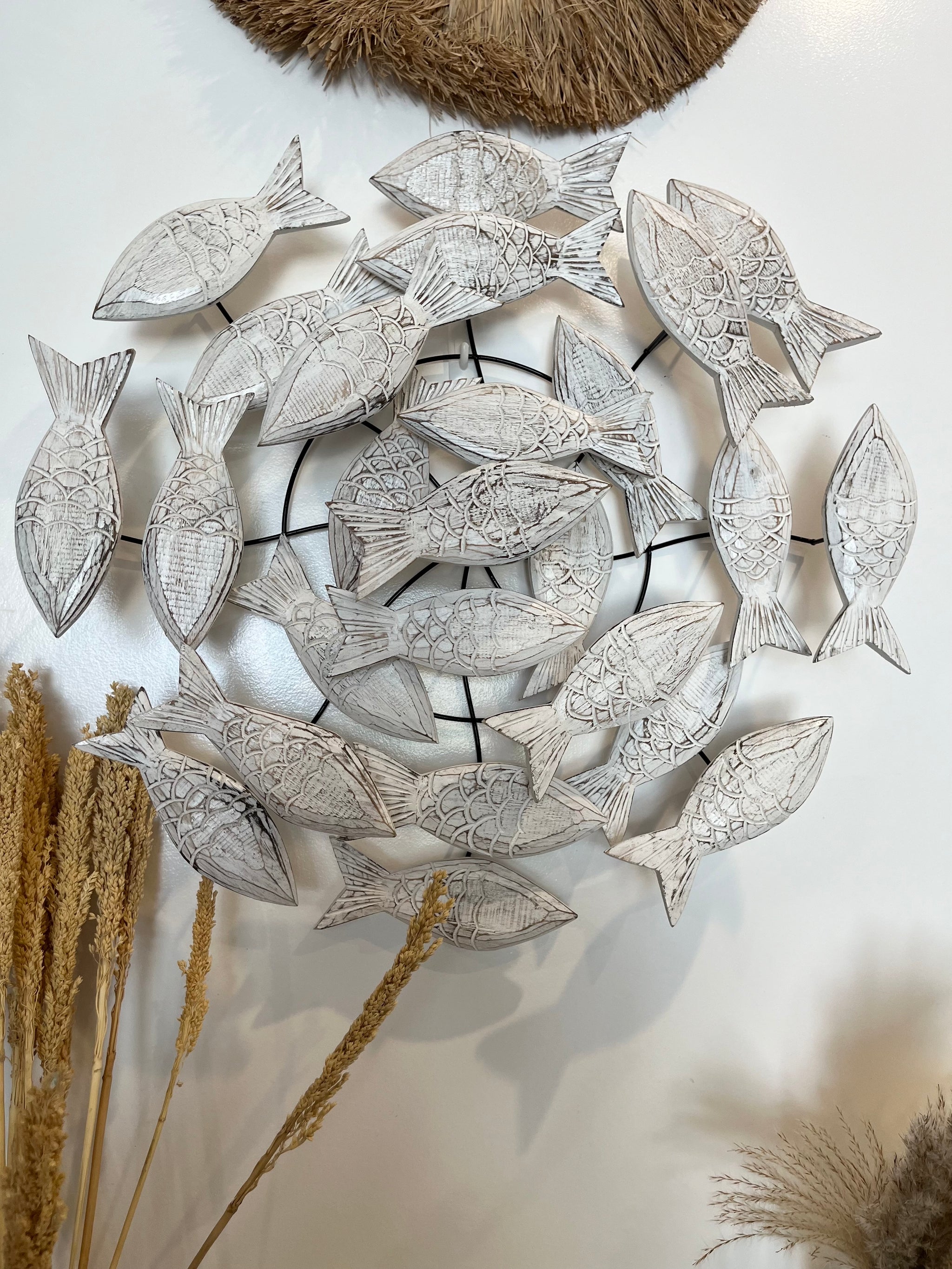 Round metal hanging with timber fish