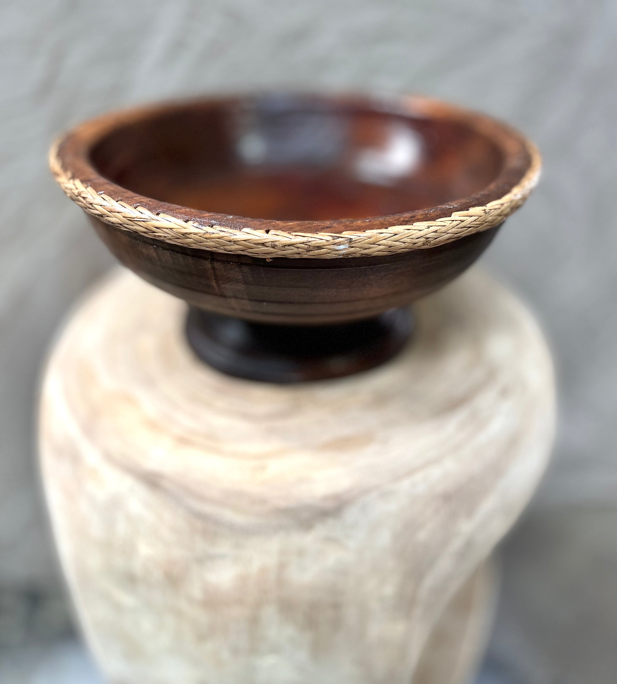 Brown timber pedestal with rattan edge detail.