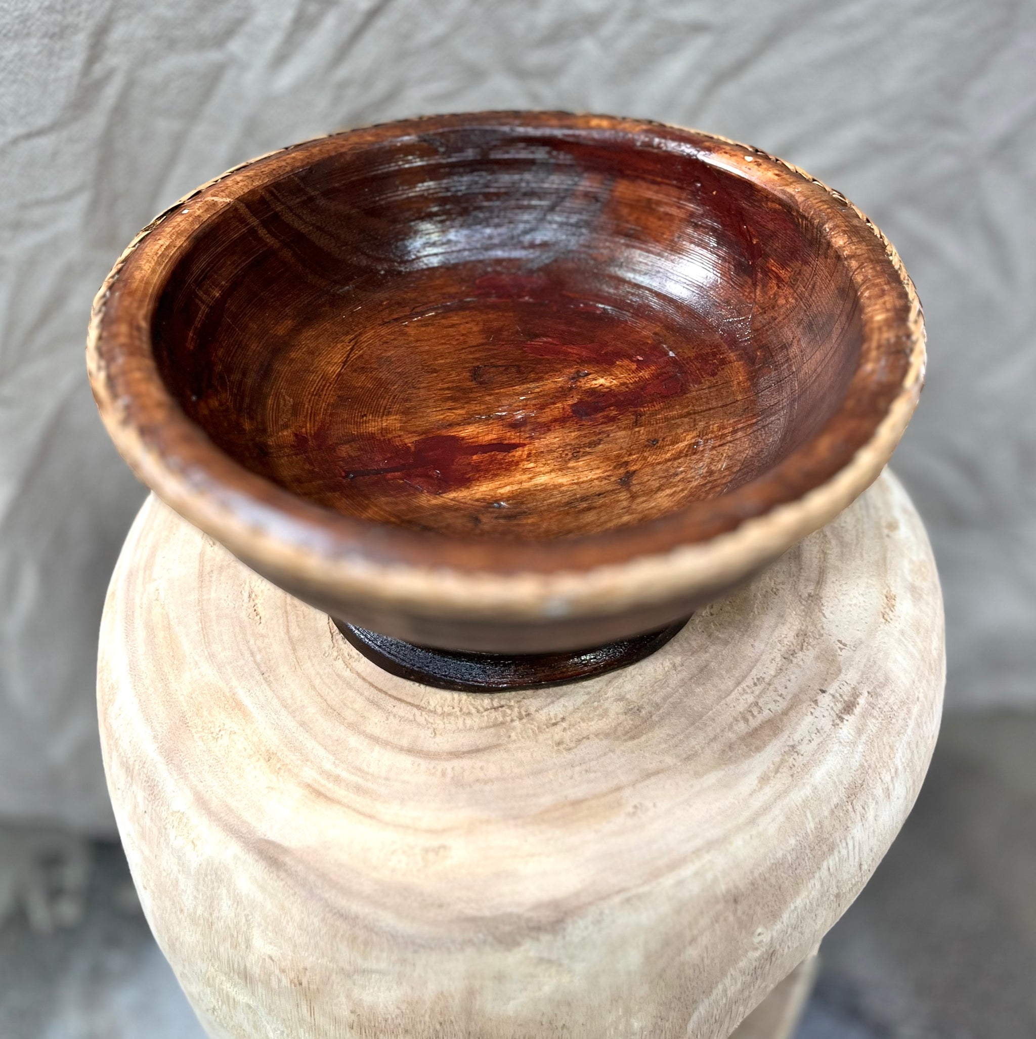 Brown timber pedestal with rattan edge detail.