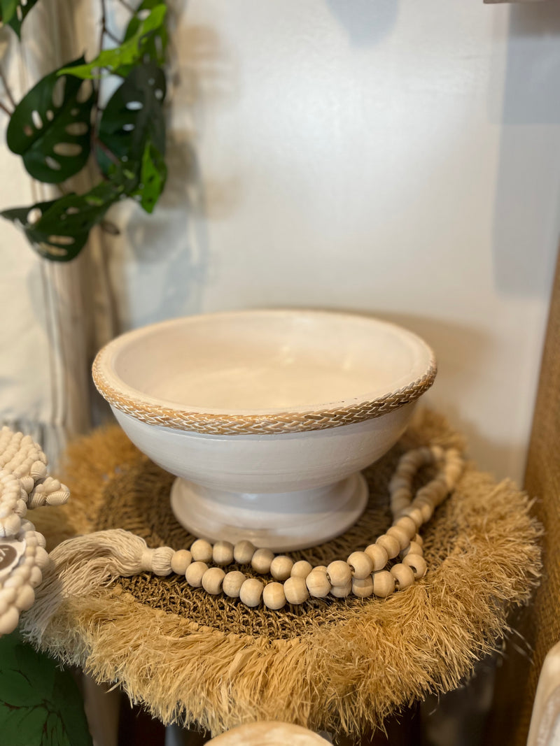 White timber pedestal platter with rattan edge detail.