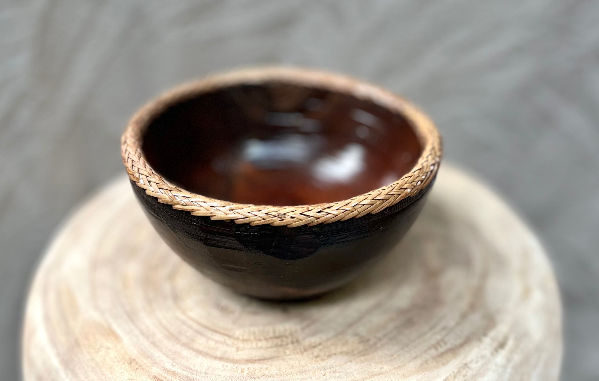 Brown timber bowl with rattan edge detail. S