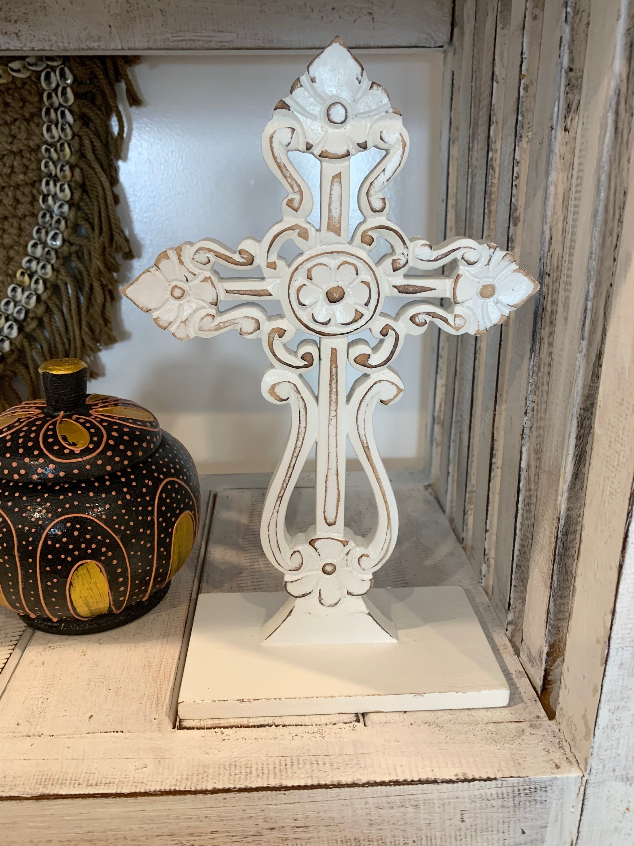 White carved cross on stand.