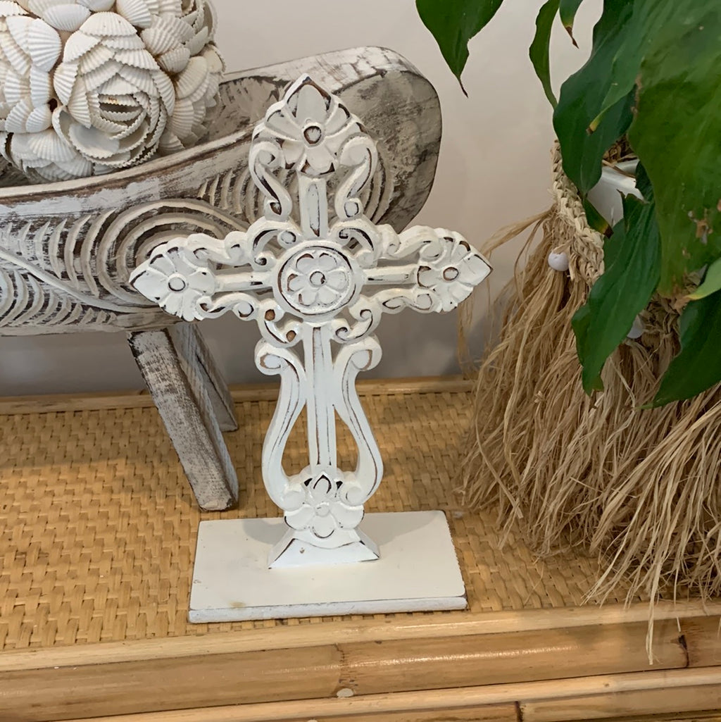 White carved cross on stand.